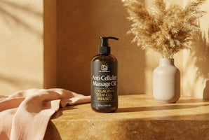 A bottle of M3 Naturals massage oil on a stone surface with linen and dried flowers in a warm, sunlit spa setting.